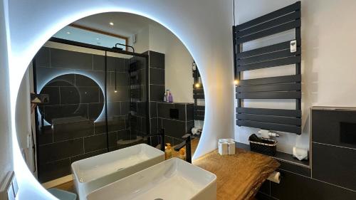a bathroom with a sink and a shower and a mirror at Loipenteufel - Zentral modern & am Lift mit Garage in Winterberg