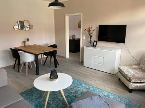 a living room with a couch and a table with a television at discovAIXR - Super Zentral mit Parkplatz, Küche, Netflix und mehr in Eisenach