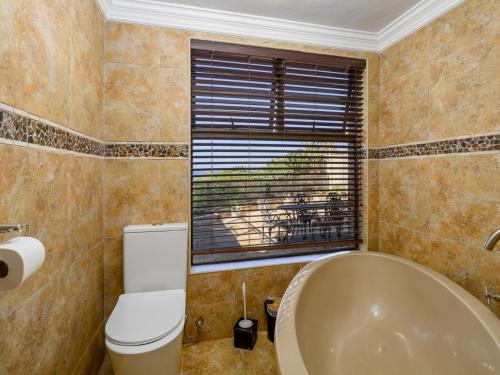 a bathroom with a tub and a toilet and a window at Seagull Villa in Margate