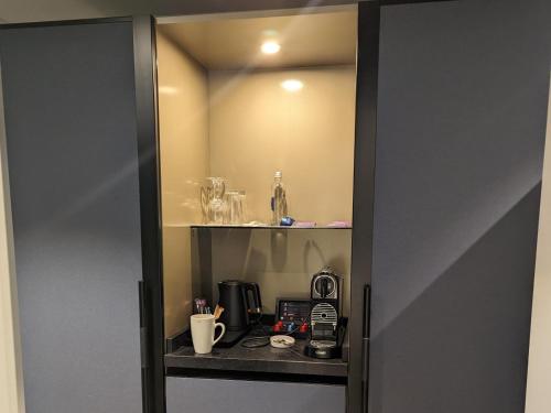a room with a cabinet with a coffee maker in it at Seagull Villa in Margate