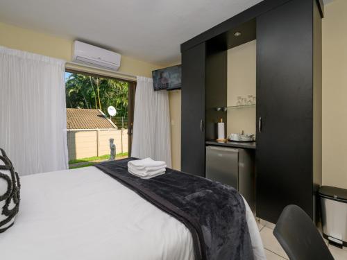 a bedroom with a large white bed and a kitchen at Seagull Villa in Margate