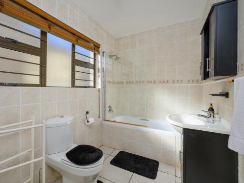 a bathroom with a toilet and a sink and a tub at Seagull Villa in Margate