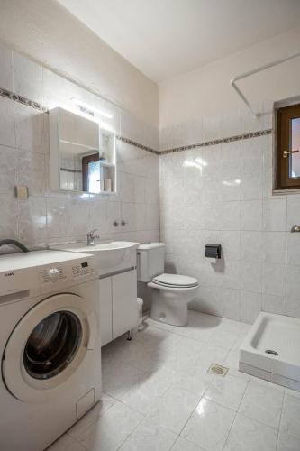 a white bathroom with a washing machine in it at Kastelli retreat in Lákkoma