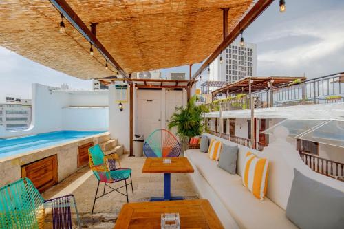 a rooftop patio with chairs and a pool on a building at La Dominica Hotel Boutique in Cartagena de Indias