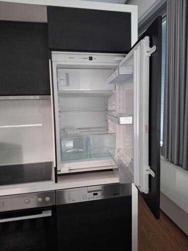an empty refrigerator with its door open in a kitchen at Apartmens Libertas in Vienna