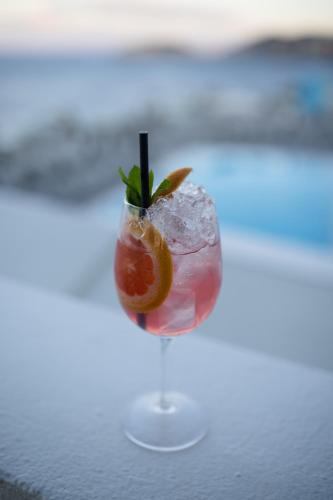 a cocktail with a lemon and ice on a table at Peninsula Resort & Spa in Agia Pelagia
