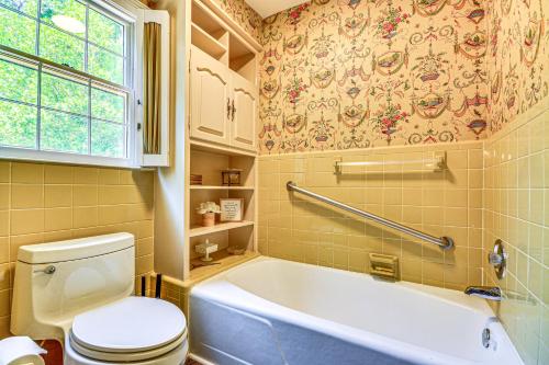 a bathroom with a tub and a toilet and a window at 2 Mi to Main St Thomasville Family Home with Games in Thomasville