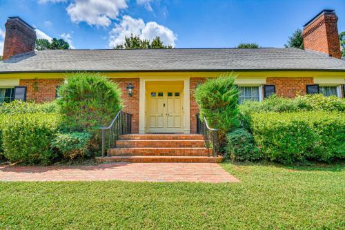 a brick house with a yellow door and stairs at 2 Mi to Main St Thomasville Family Home with Games in Thomasville