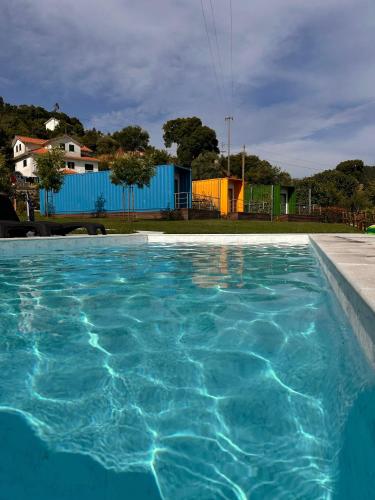 a large pool of blue water in a yard at Vizinhos do Sol Turismo Rural in Valadares