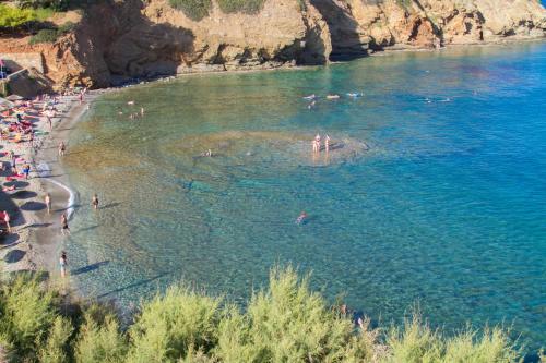 a group of people in the water at a beach at Peninsula Resort & Spa in Agia Pelagia
