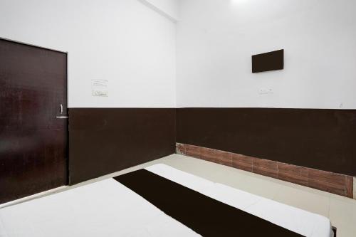 an empty room with a bed and a door at HOTEL O SP GRAND Sidhauli in Mahmūdābād