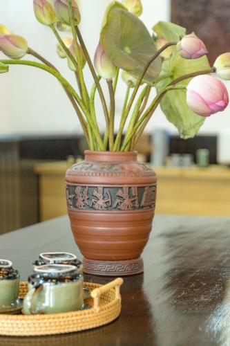 a vase with flowers in it sitting on a table at Peaceful 2 Hotel in Vientiane