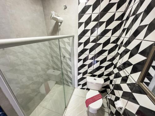 a bathroom with a black and white checkered wall at Pousada Raio de Sol in Lençóis