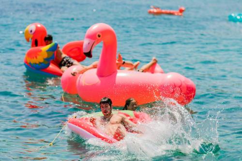 a group of people riding on inflatables in the water at Peninsula Resort & Spa in Agia Pelagia