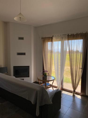 a bedroom with a bed and a table and a window at Kryoneri village in Kryonéri