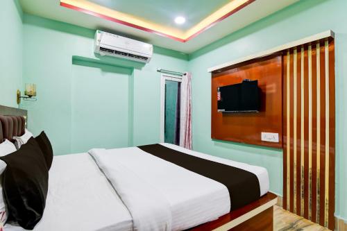 a bedroom with a bed and a tv on the wall at Hotel O GALAXY in Jagatpur