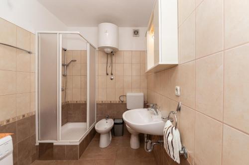 un bagno con lavandino, WC e doccia di Apartment Vrba a Supetar (San Pietro di Brazza)