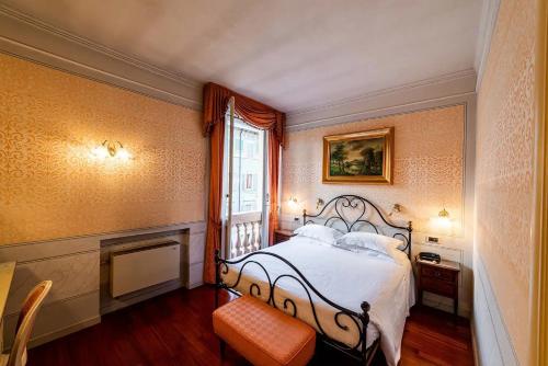 a bedroom with a bed and a fireplace and a window at Phi Hotel Canalgrande in Modena