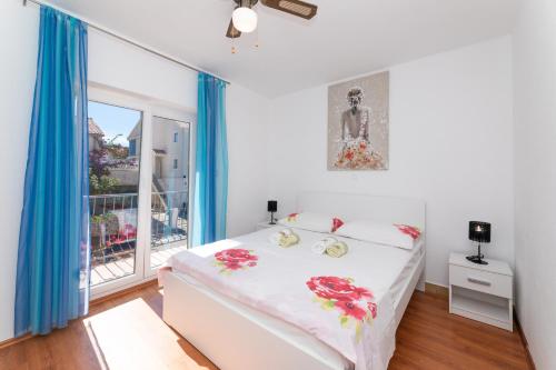 una camera da letto con un letto e una grande finestra di Apartment Vrba a Supetar (San Pietro di Brazza)