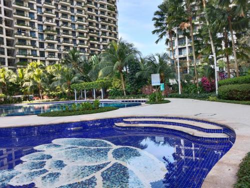a swimming pool in front of a large building at Holiday Home at Forest City with TV Box & 3 Bedrooms 1 Bathroom 4-6pax 1618 in Gelang Patah