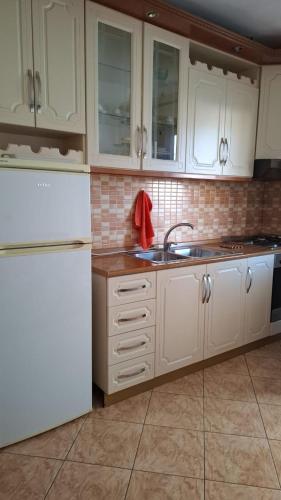 a kitchen with white cabinets and a white refrigerator at Il Nido del Viaggiatore in Orikum