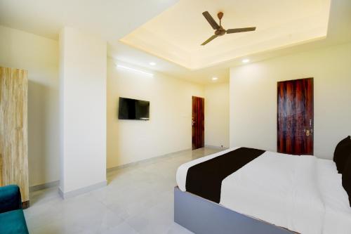 Un dormitorio con una cama y un ventilador de techo. en Hotel O Classy Castle, en Jaipur