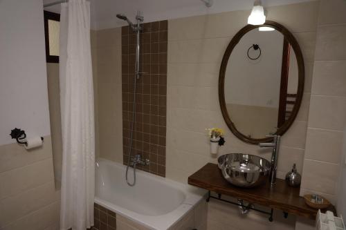 a bathroom with a tub and a sink and a mirror at Fuentepiedra Casa Rural Categoría Superior in Almodóvar del Río