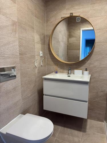 a bathroom with a white toilet and a mirror at WHome Seaside Getaway Beachfront Apartment in Estoril