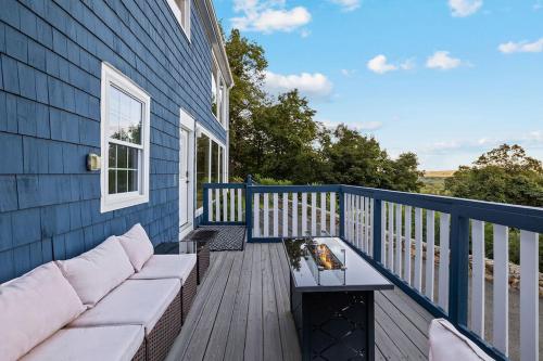 a porch with a couch and a table on a deck at Modern 3BR Mountain Escape | FirePit • Workstation in Suffern