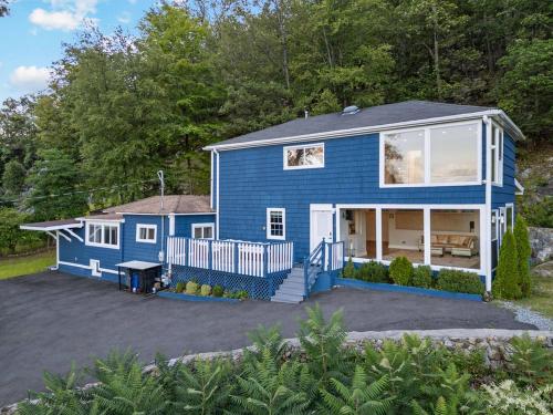 a blue tiny house with a lot of windows at Modern 3BR Mountain Escape | FirePit • Workstation in Suffern
