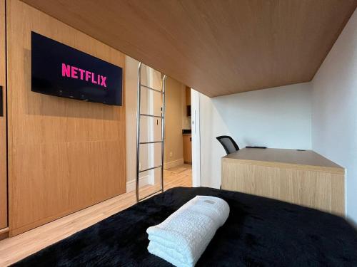 a bedroom with a bed and a desk with a television at Flat Hotel Slaviero GRU 2 Quartos até 6p | Delfhy in Vila Gopoúva