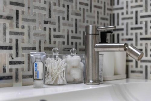 a bathroom sink with a faucet and toothbrushes at Modern 3BR Mountain Escape | FirePit • Workstation in Suffern