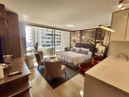 a bedroom with a bed and a living room at Exclusive and Secure Apartment Parque Arauco Las Condes in Santiago