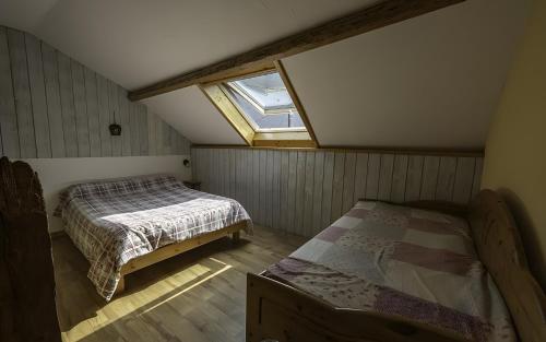 a attic bedroom with a bed and a window at Le Cabanon Studio 35 M² in Doussard