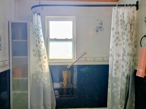 a shower curtain in a bathroom with a window at Explore New York from Queens in Queens