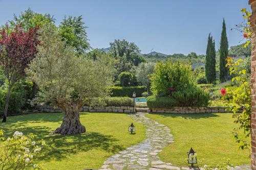 a garden with a tree and a stone path at Scappo in Umbria, casale della quiete in Montecchio