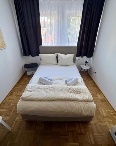a bedroom with a large bed in front of a window at Altstadt Apartmenthaus in Kassel