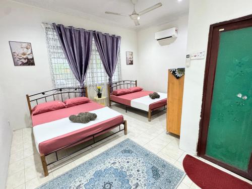 two beds in a room with purple curtains at D'Widuri Homestay Bandar Melaka in Melaka