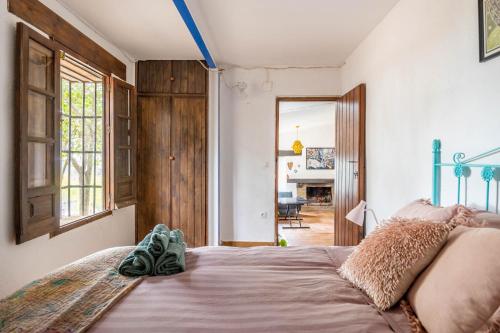 a bedroom with a bed with shoes sitting on it at Cottage with Jacuzzi, Sierra Norte, close to Seville in Guillena