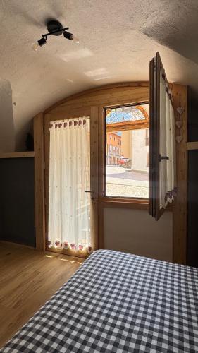 a room with a bed and a large window at Coriva Homes - Cogolo Stube in Cogolo