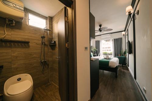 a bathroom with a toilet and a bedroom at Willow Hanoi Old Quarter in Hanoi