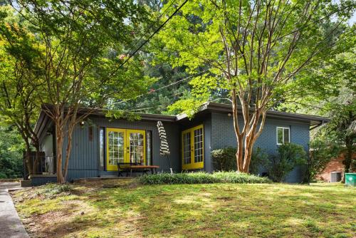 a small blue house with yellow doors and a yard at Joshua Tree in Atlanta