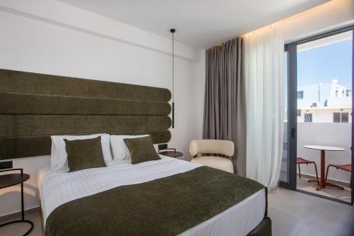 a hotel room with a large bed and a balcony at Ermou 44 City Hotel in Faliraki