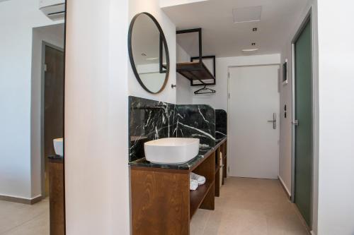 a bathroom with a sink and a mirror at Ermou 44 City Hotel in Faliraki