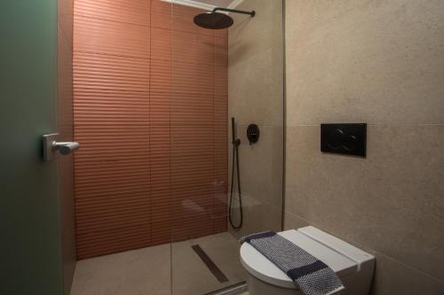 a bathroom with a shower with a toilet in it at Ermou 44 City Hotel in Faliraki