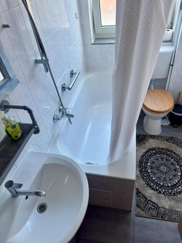 a bathroom with a tub and a sink and a toilet at Altstadt Apartmenthaus in Kassel