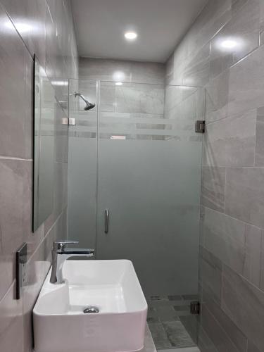 a white bathroom with a sink and a shower at Hotel Riviera in San Juan de los Lagos
