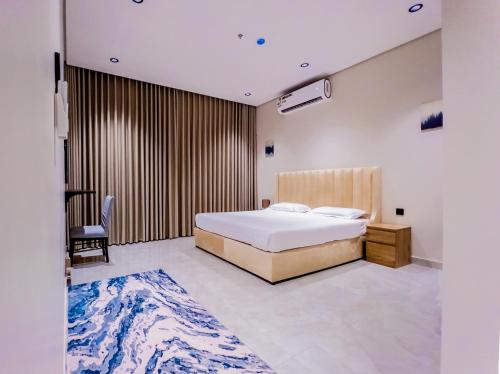 een slaapkamer met een bed, een bureau en een stoel bij Comfy apartment in AlKhobar in Al Khobar