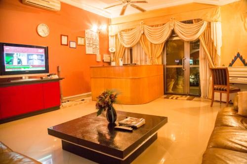 a living room with a couch and a tv at Magnolia lodge in Accra