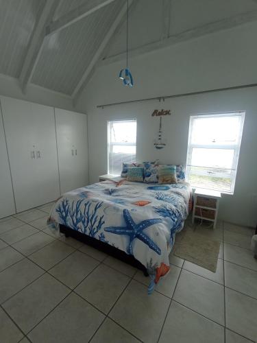 a bedroom with a bed with an octopusidered bedspread at The Tides Holiday Home in St Helena Bay